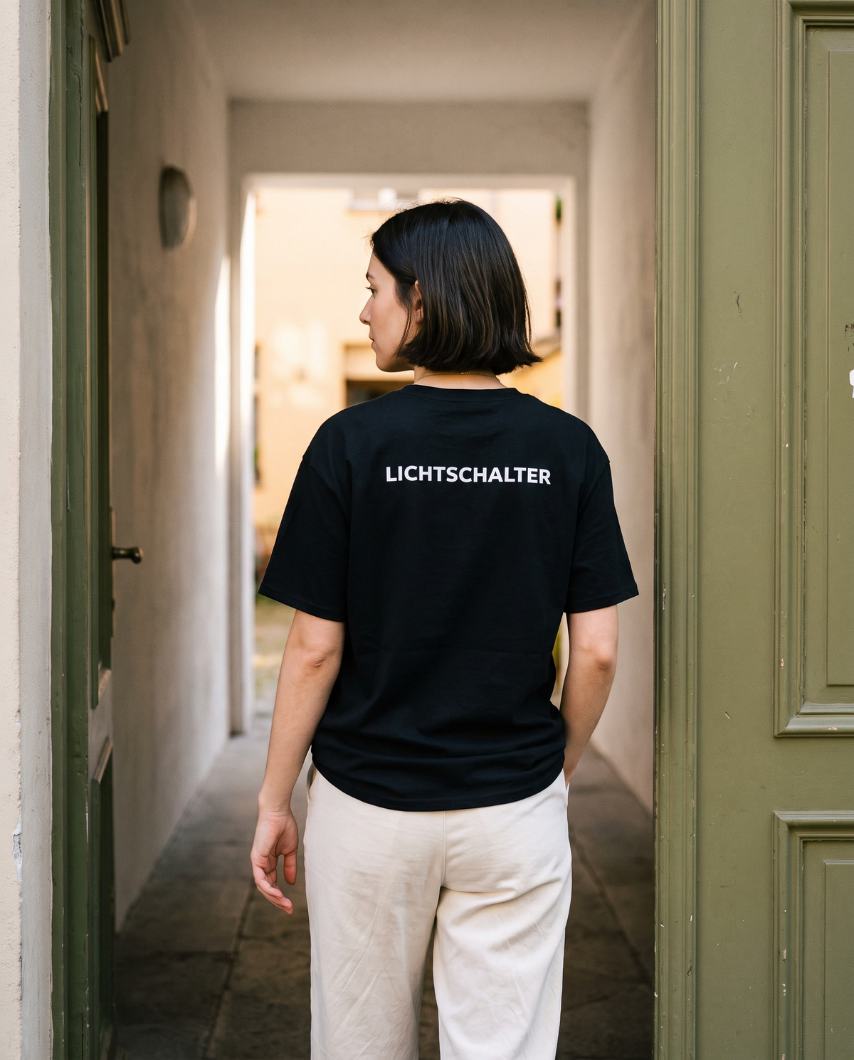 Schwarzes Lichtschalter-Shirt, getragen in einem Hauseingang